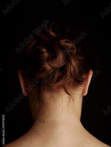 Photography head and neck of red-haired woman, portrait from behind, chiaroscuro