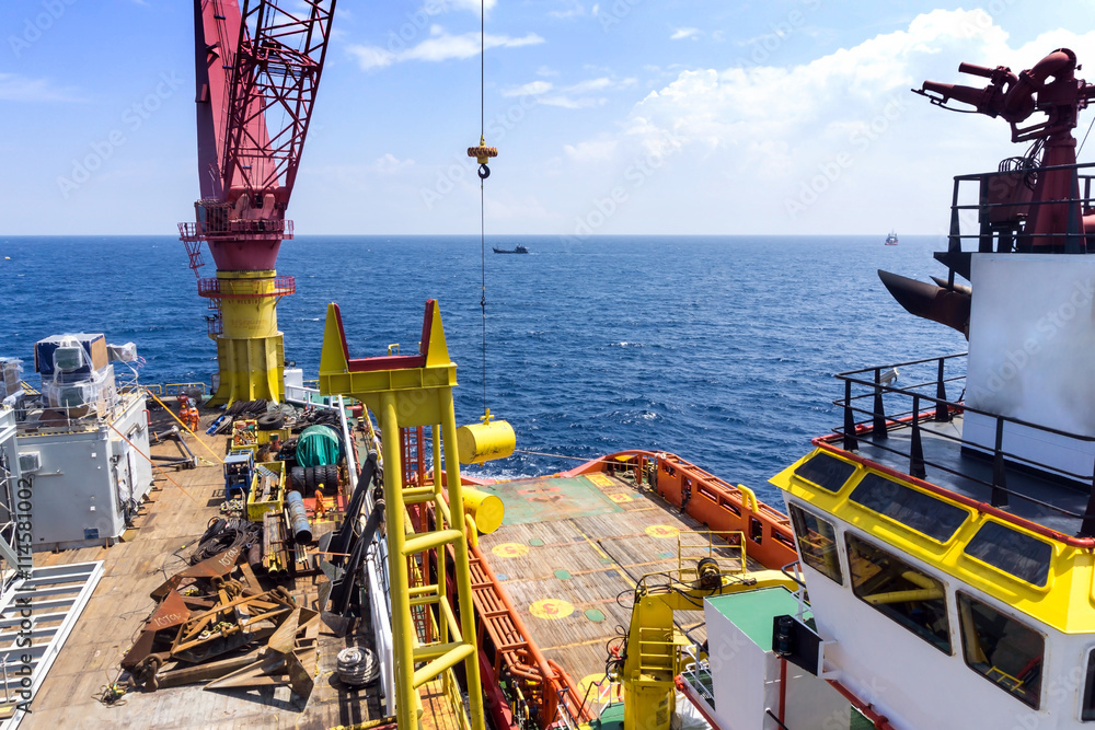 Offshore workers handling anchor to be lifted for deployment on ...