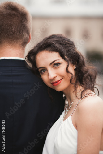 Beautiful bride leaned on back of the groom