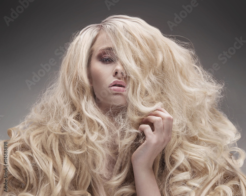 Closeup portrait of a blonde with a fluffy, curly hairstyle