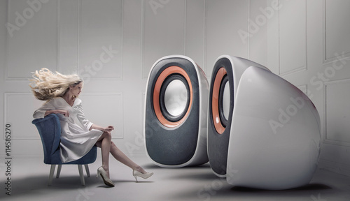 Young fashionable lady listening to big loudspeakers photo