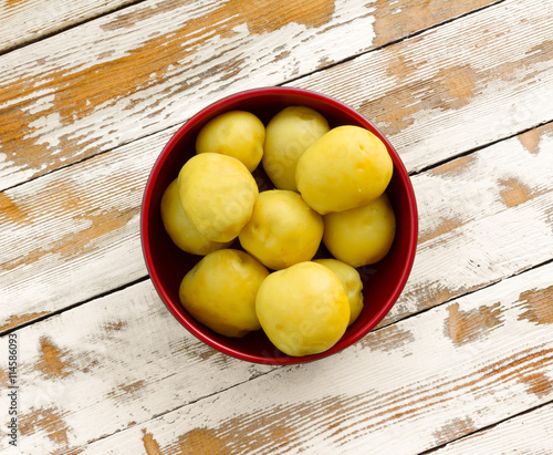 Slika na platnu purified boiled yellow potatoes in a red bowl on the old wooden table with the r
