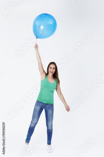 Portrait of young woman floating with balloon © sanneberg
