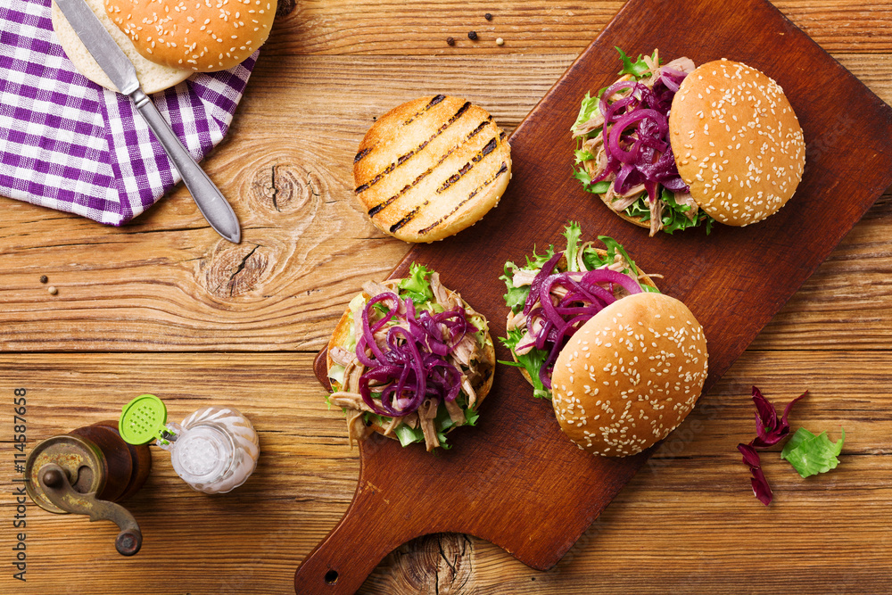 Burger with meat of duck with red onion and lettuce.