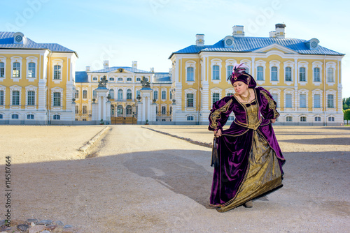 Historical cosplay. Beautiful woman in the similitude of Isabella d'Este Mantua, marquess of Italian ancient dress near palace