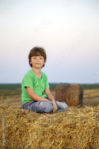 boy in a haystack in the field