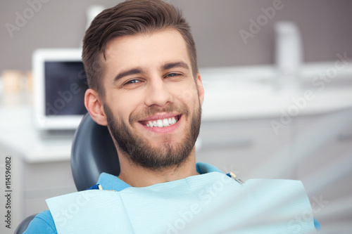 Portrait of happy patient in dental chair.
