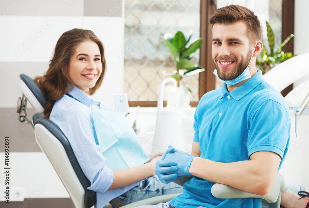 Portrait of a male dentist and young happy female patient. Portrait of a male dentist and young happy female patient.