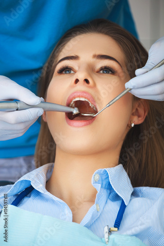 Young woman getting her teeth checked by a dentist.