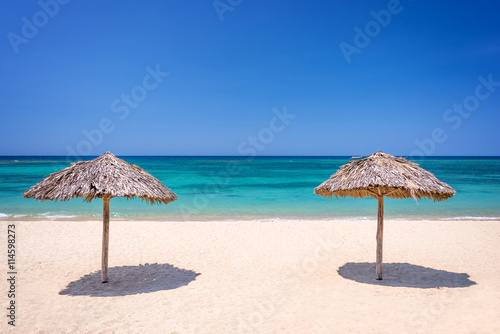 Fototapeta Naklejka Na Ścianę i Meble -  Straw umbrella on a beautiful tropical beach
