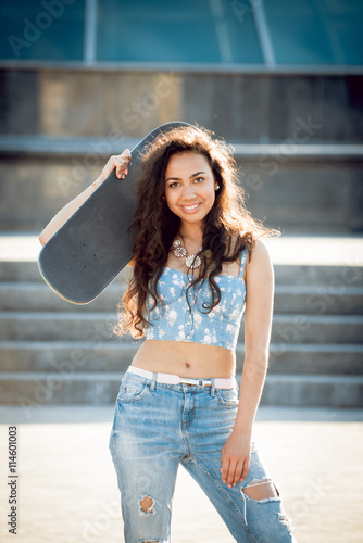 Young girl with skateboard.