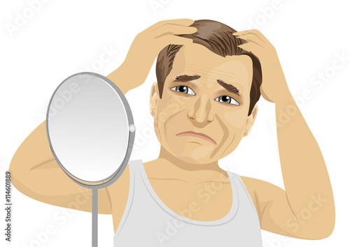 Mature man looking in mirror worried about hair loss