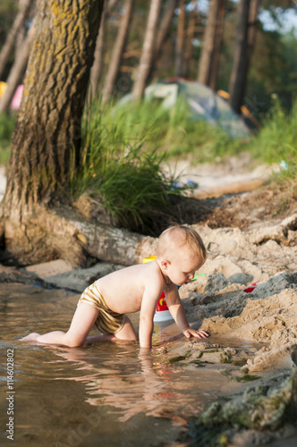 child bathes in the river