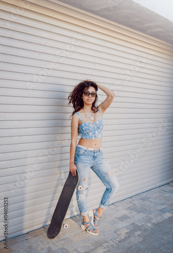 Young girl with skateboard.