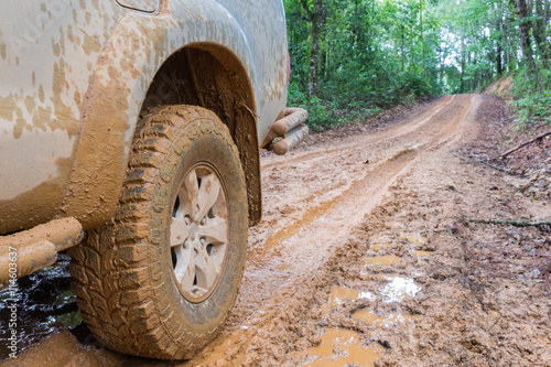 Wheel closeup in a countryside landscape with a muddy road