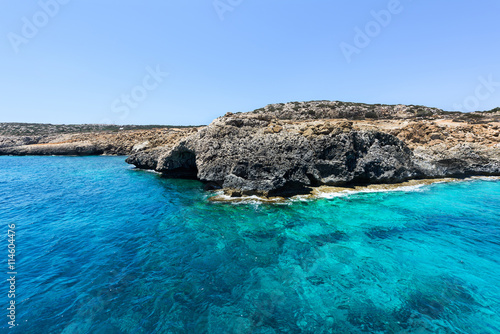 Pirate bay in protaras paralimni, white church, blue sea and rocks, cyprus island