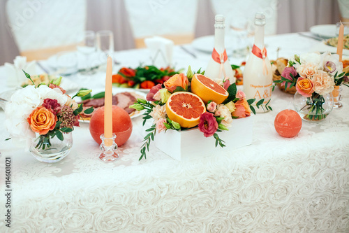 decoration of candles, grapefruit, flowers on the banquet table