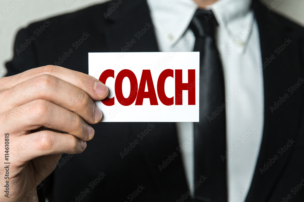 Business man holding a card with the text: Coach Business man holding a card with the text: Coach