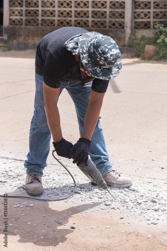 Worker repairing and drilling concrete road Worker repairing and drilling concrete road