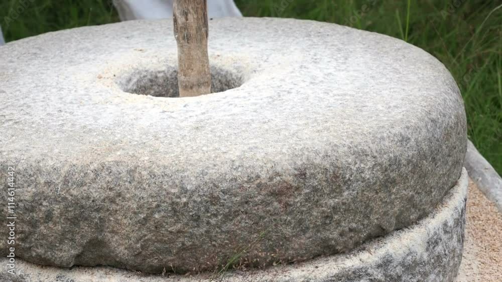 Close-up shot of historic hand-driven millstone grinding wheat Close-up shot of historic hand-driven millstone grinding wheat