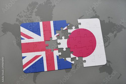 puzzle with the national flag of great britain and japan on a world map background. photo