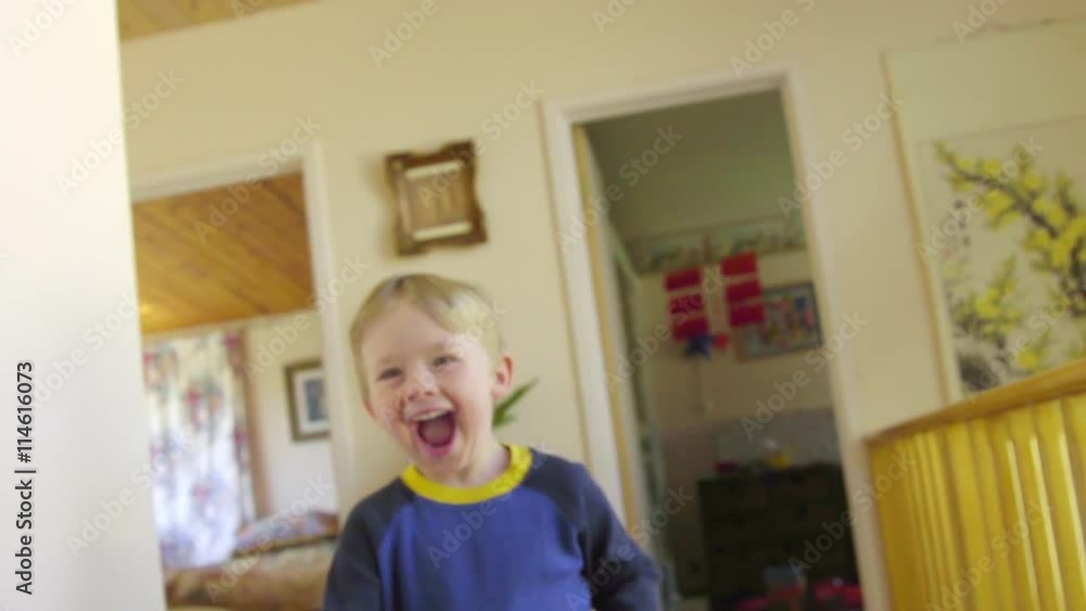 Camera tracks in front as a Laughing, joyful cute boy runs out of his bedroom into the arms of his loving mother Camera tracks in front as a Laughing, joyful cute boy runs out of his bedroom into the arms of his loving mother