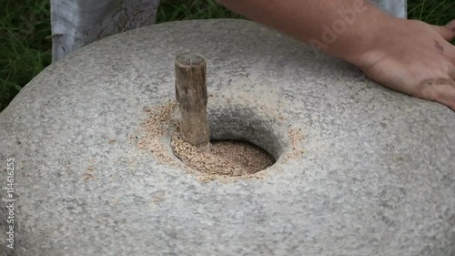 Close-up shot of historic hand-driven millstone grinding wheat