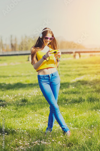Teenage girl with smartphone and headphones smiling