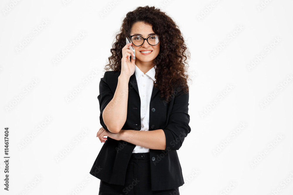 Picture of cheerful curly business girl wearing glasses talking on phone Picture of cheerful curly business girl wearing glasses talking on phone