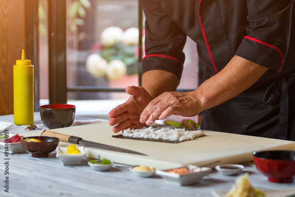 Man's hands touch white rice. Rice on nori leaf. Japanese chef prepares sushi. Best ingredients for hosomaki rolls.