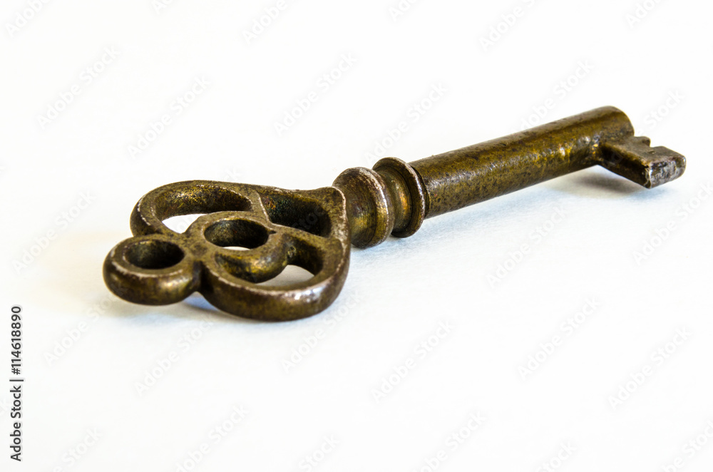 Antique brass skeleton key angled away on white background Antique brass skeleton key angled away on white background