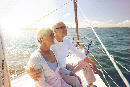 senior couple hugging on sail boat or yacht in sea