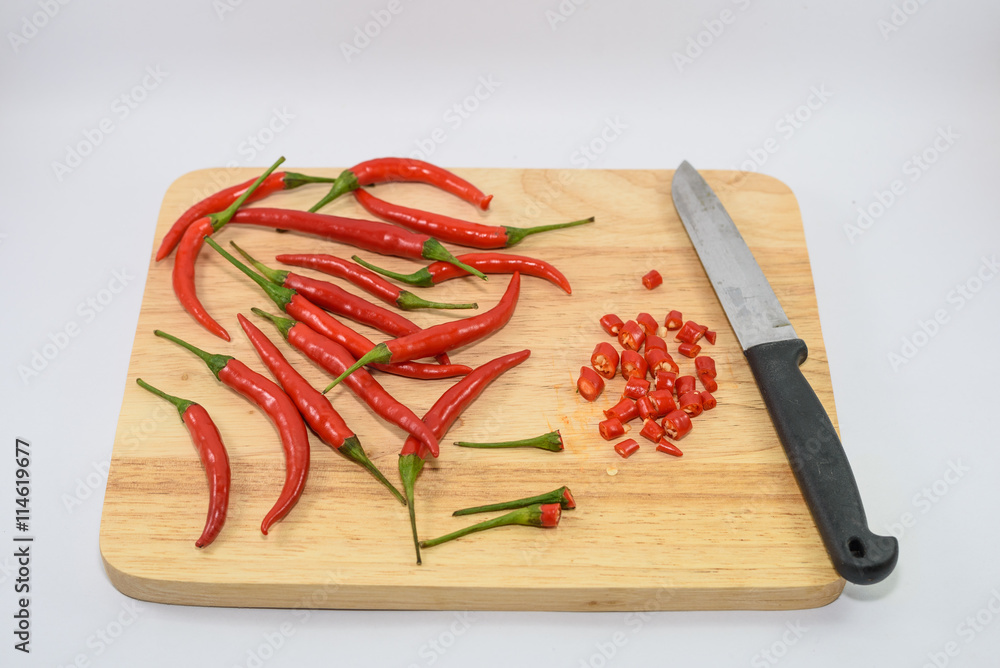 red hot chili on chopping block with a knife on white isolate red hot chili on chopping block with a knife on white isolate