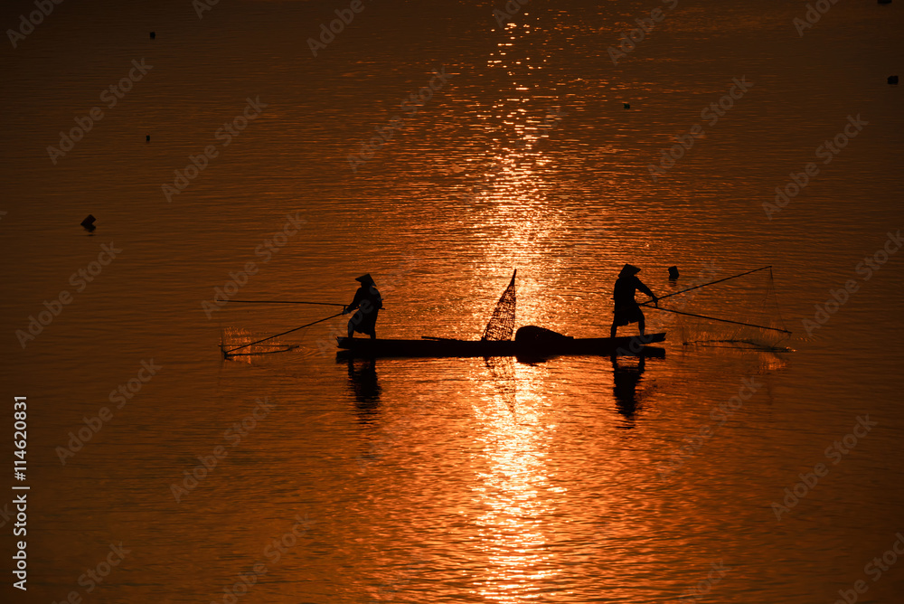 fisherman on boat with sunrise background, the Mekong River in Thailand