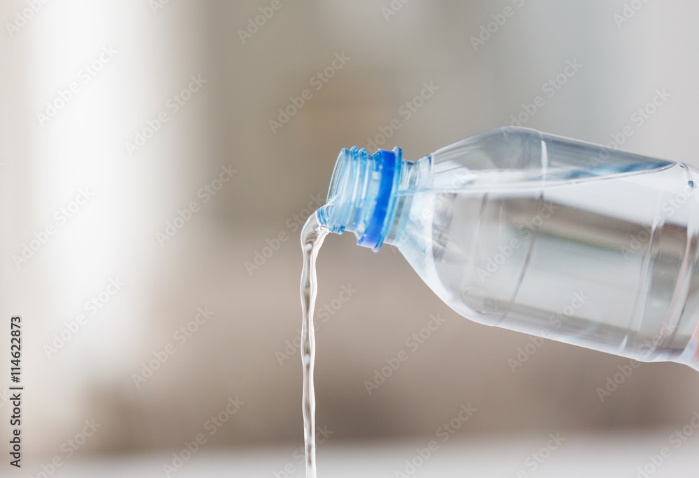 close up of water pouring from plastic bottle close up of water pouring from plastic bottle