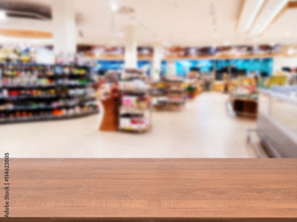 Wooden empty table in front of blurred supermarket Wooden empty table in front of blurred supermarket