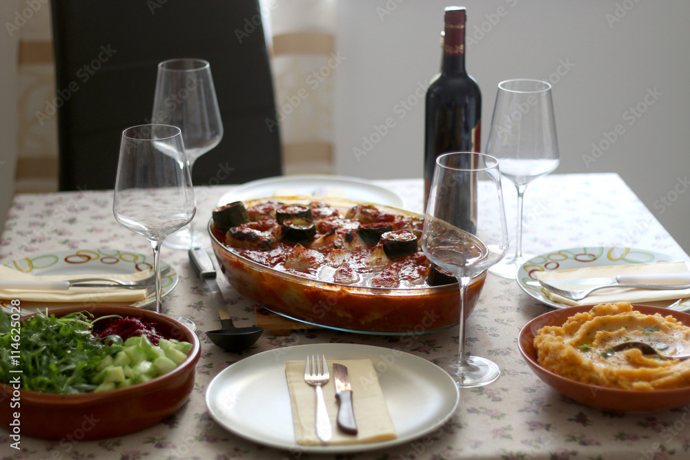Table set for four. Stuffed vegetables, mashed potatoes, salad and wine are served. Selective focus.
Table set for four. Stuffed vegetables, mashed potatoes, salad and wine are served. Selective focus.