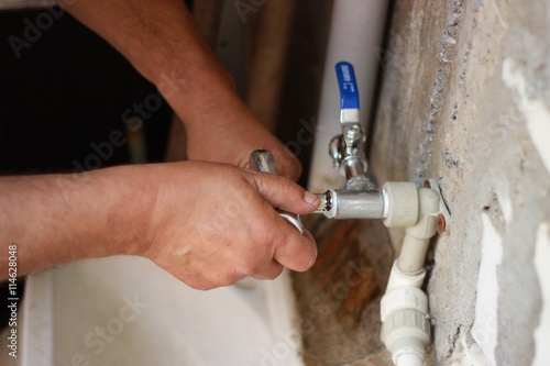 Plumber screwing plumbing fittings
