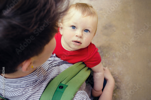 Mother having her cute little son in baby carrier photo