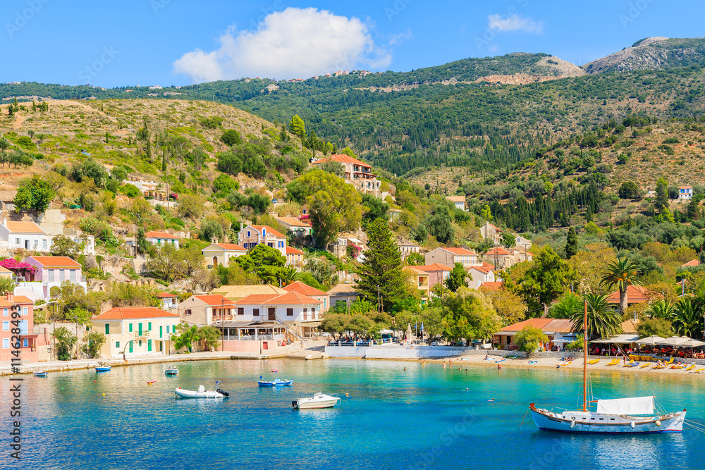 Colorful houses of Assos village and yacht boat in sea bay on Kefalonia island, Greece