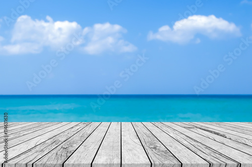 blur sea beach background with white wooden floor board.