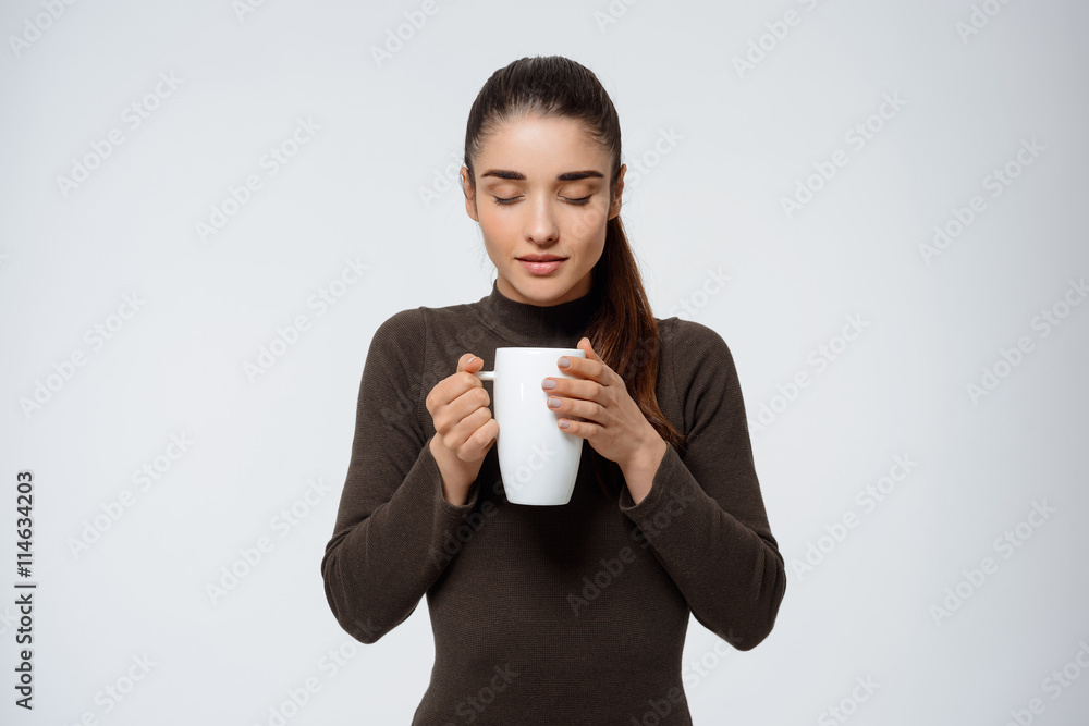 Beautiful young girl holding cup of tea in hands Beautiful young girl holding cup of tea in hands
