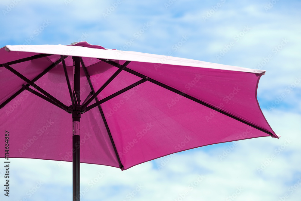 Obraz premium Dark pink parasol on blue coudy sky