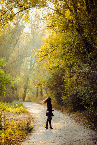 girl walks in beautiful autumn park