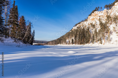 Snowmobile track on frozen mountain river