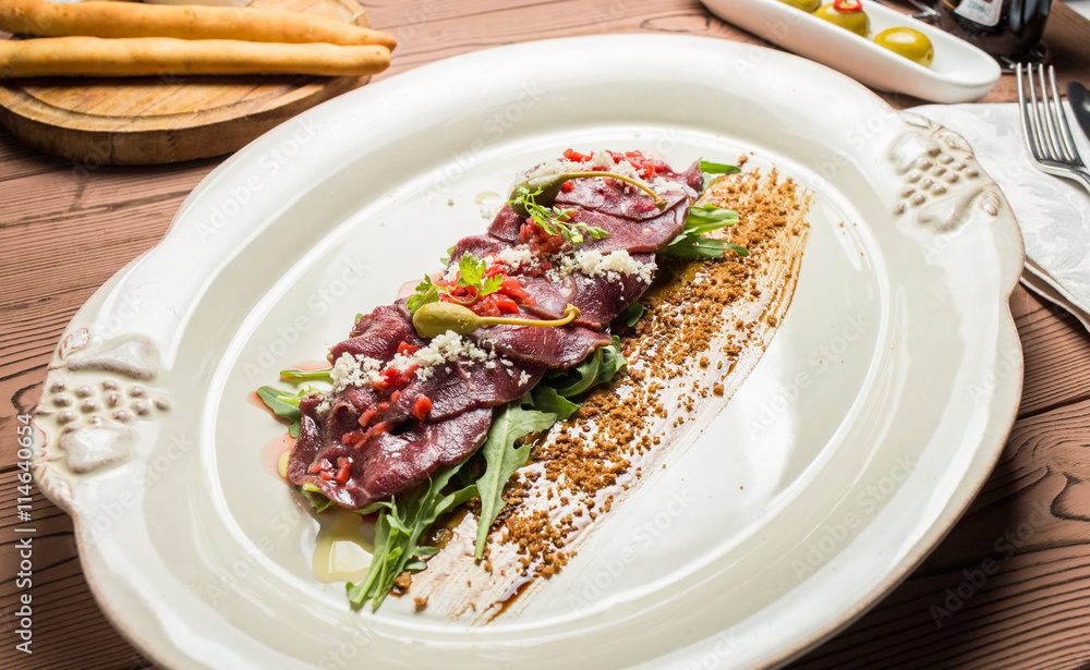 carpaccio with deer served on white plate carpaccio with deer served on white plate