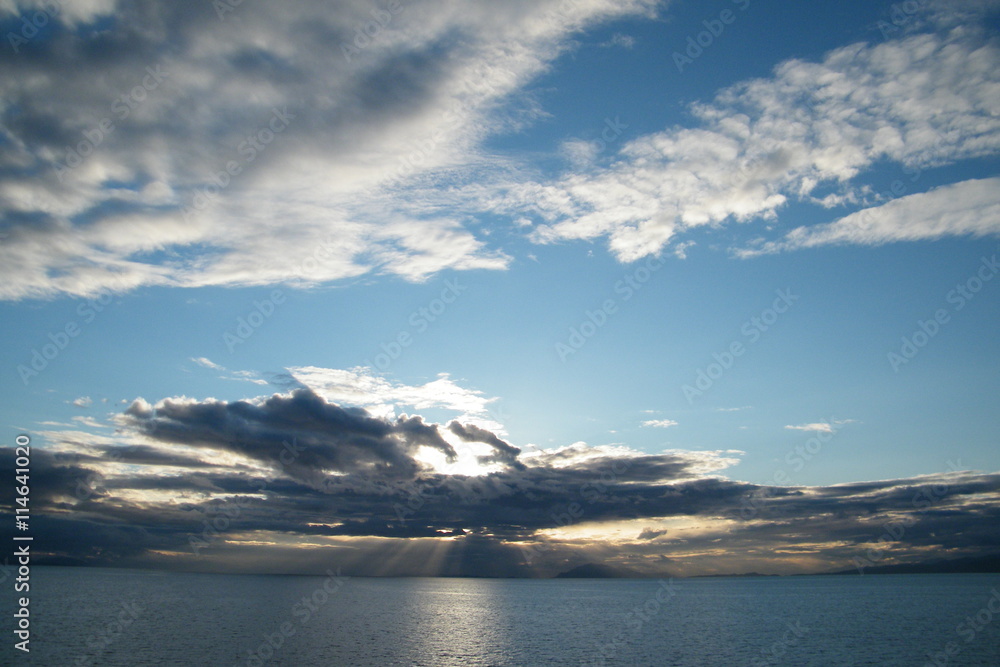 Yellow Sunbeams Through the Clouds on a Calm Ocean Yellow Sunbeams Through the Clouds on a Calm Ocean