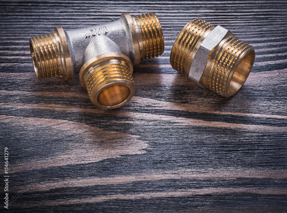 Brass equal tee nipple hose connector on wooden background plumb Brass equal tee nipple hose connector on wooden background plumb