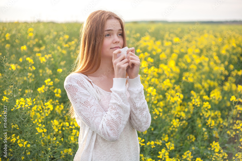 Pollen allergy, girl sneezing in a rapeseed field of flowers. Pollen allergy, girl sneezing in a rapeseed field of flowers.