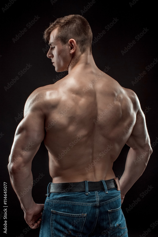 Muscular bodybuilder guy doing posing over black background Muscular bodybuilder guy doing posing over black background